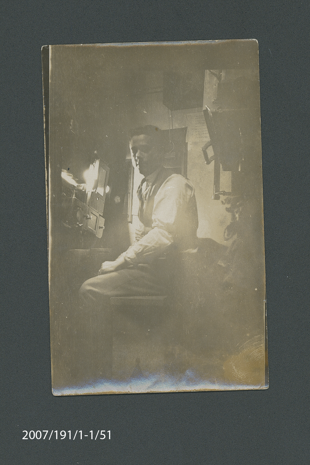 Photograph of Stan Allan seated in projection room at Haymarket Theatre, Sydney