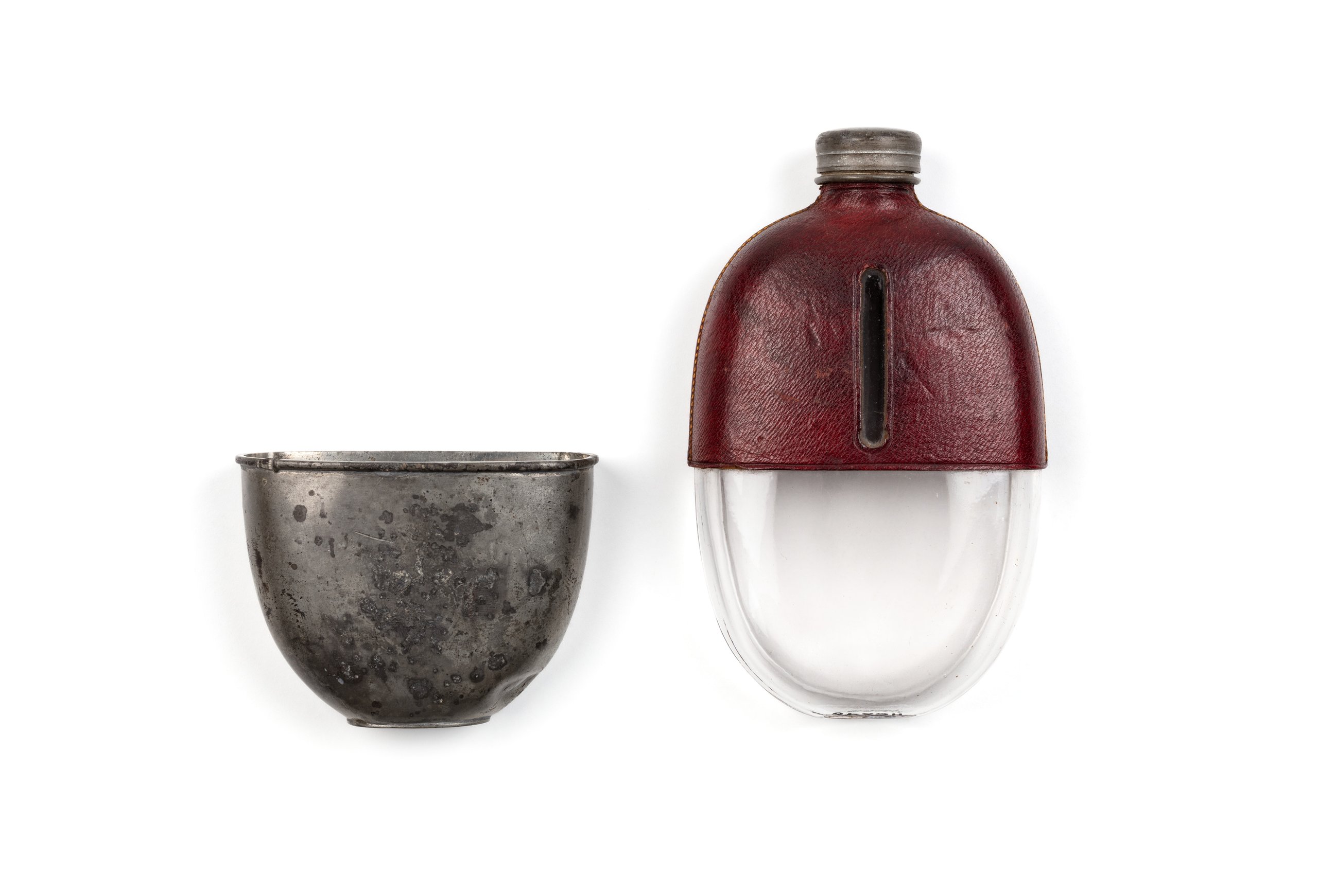 Oval shaped glass brandy flask with a red leather and metal cover