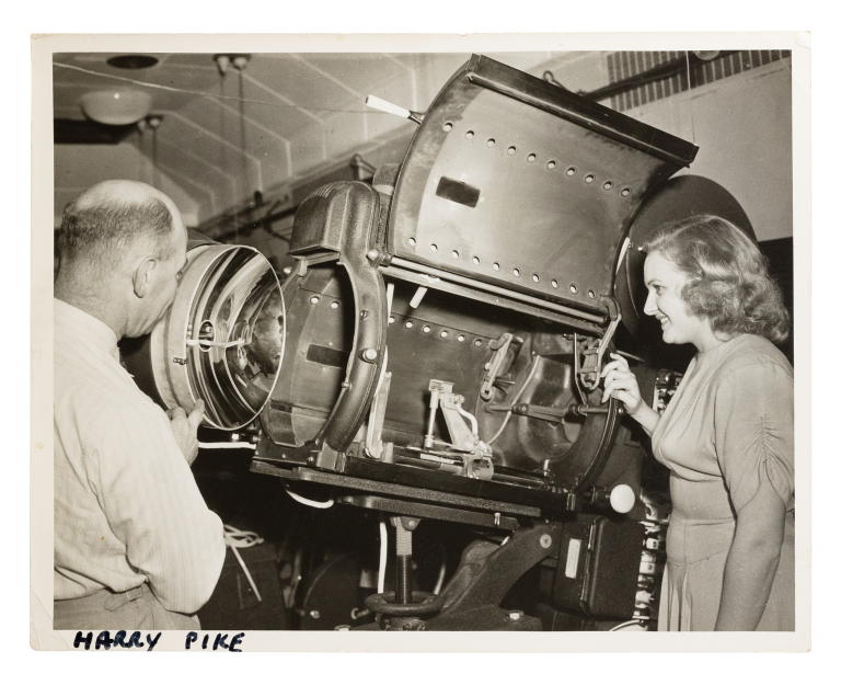 Photograph of Harry Pike and unidentified woman looking at a Centrex projector