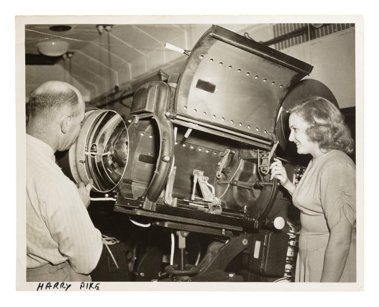 Photograph of Harry Pike and unidentified woman looking at a Centrex projector