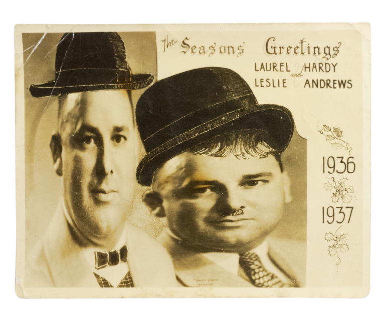 Photograph of Christmas card featuring two men dressed as Laurel and Hardy