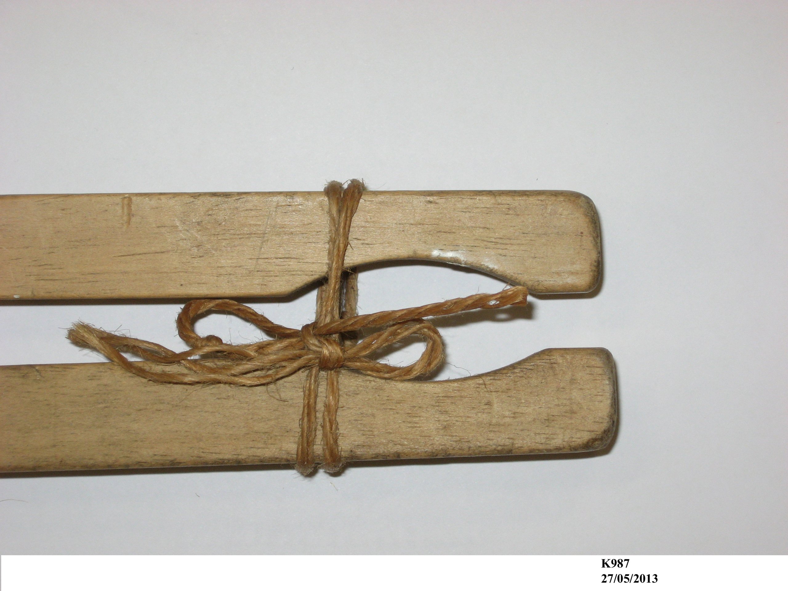 A pair of wooden laundry tongs.