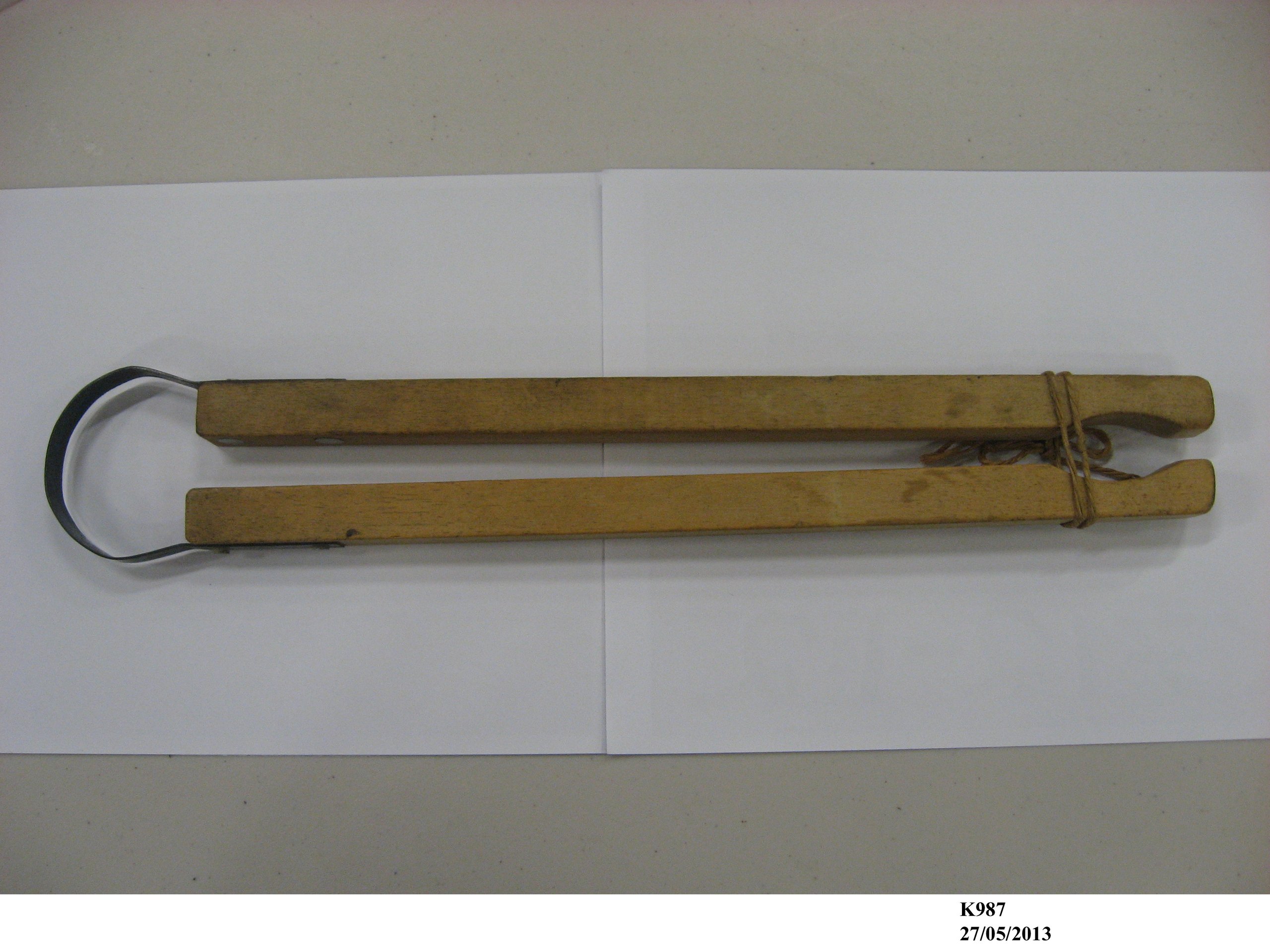 A pair of wooden laundry tongs.