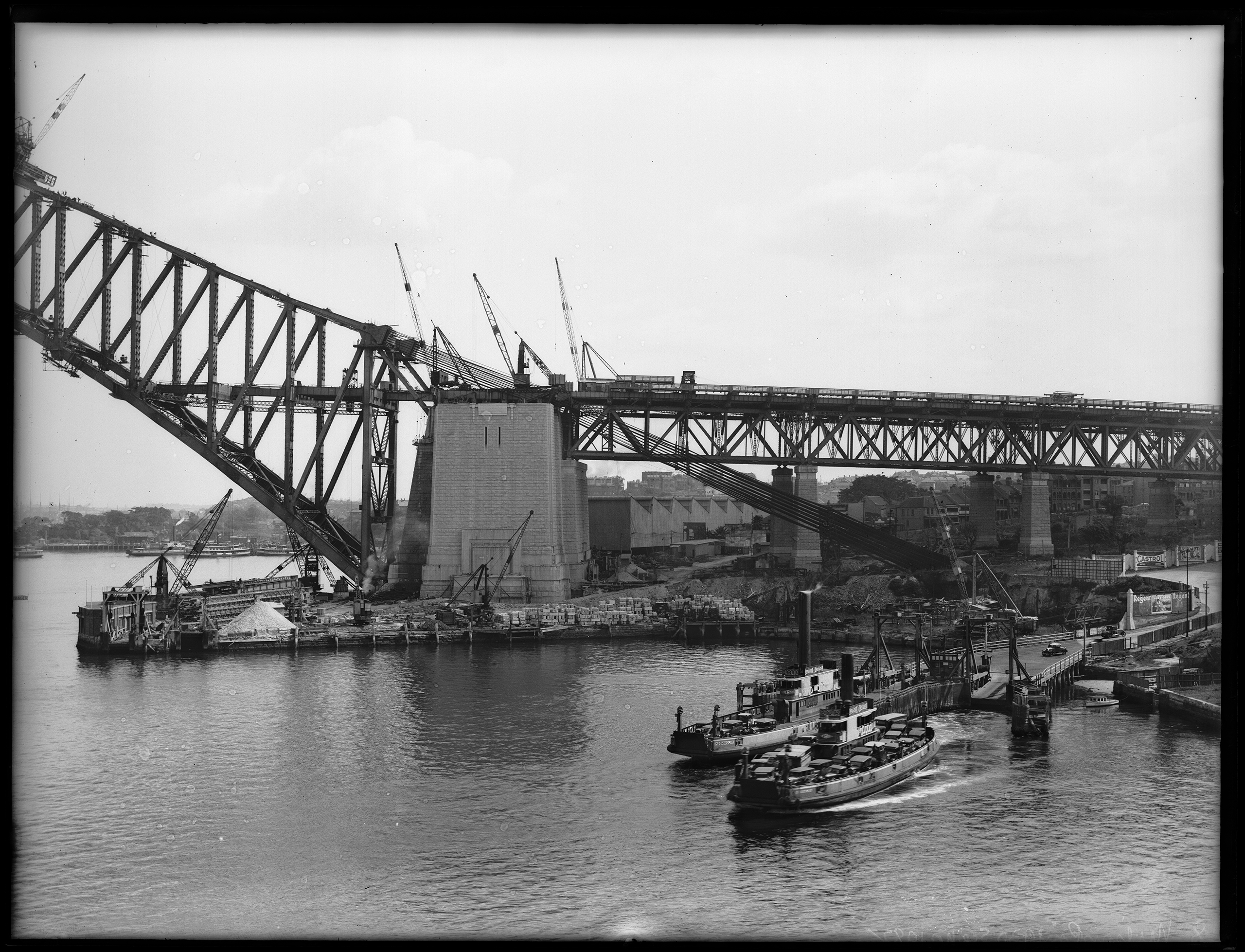 Glass plate negative of Sydney Harbour Bridge under construction and Jeffrey Street vehiclualr ferry ramp, 1930