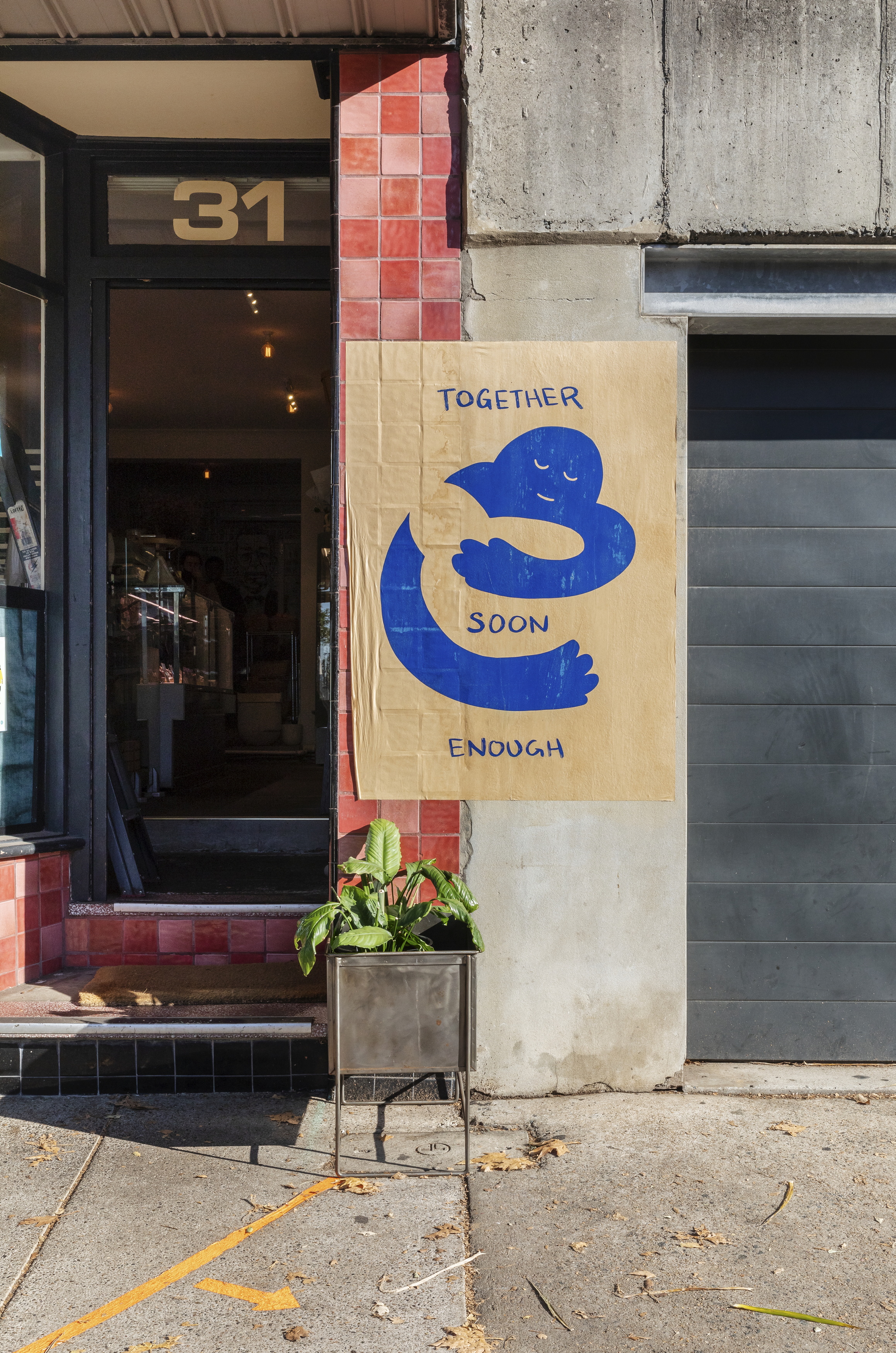 Digital photograph 'Omeio Deli, MacDonald St, Paddington showing Peter Drew’s ‘Together Soon Enough’ print, 28 May 2020' by Katherine Lu