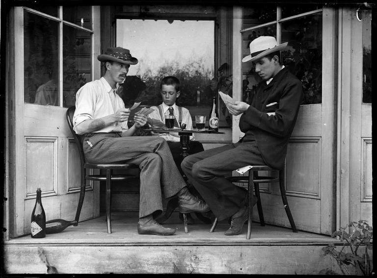 Glass plate negative, stage set of three men playing cards in an alcove