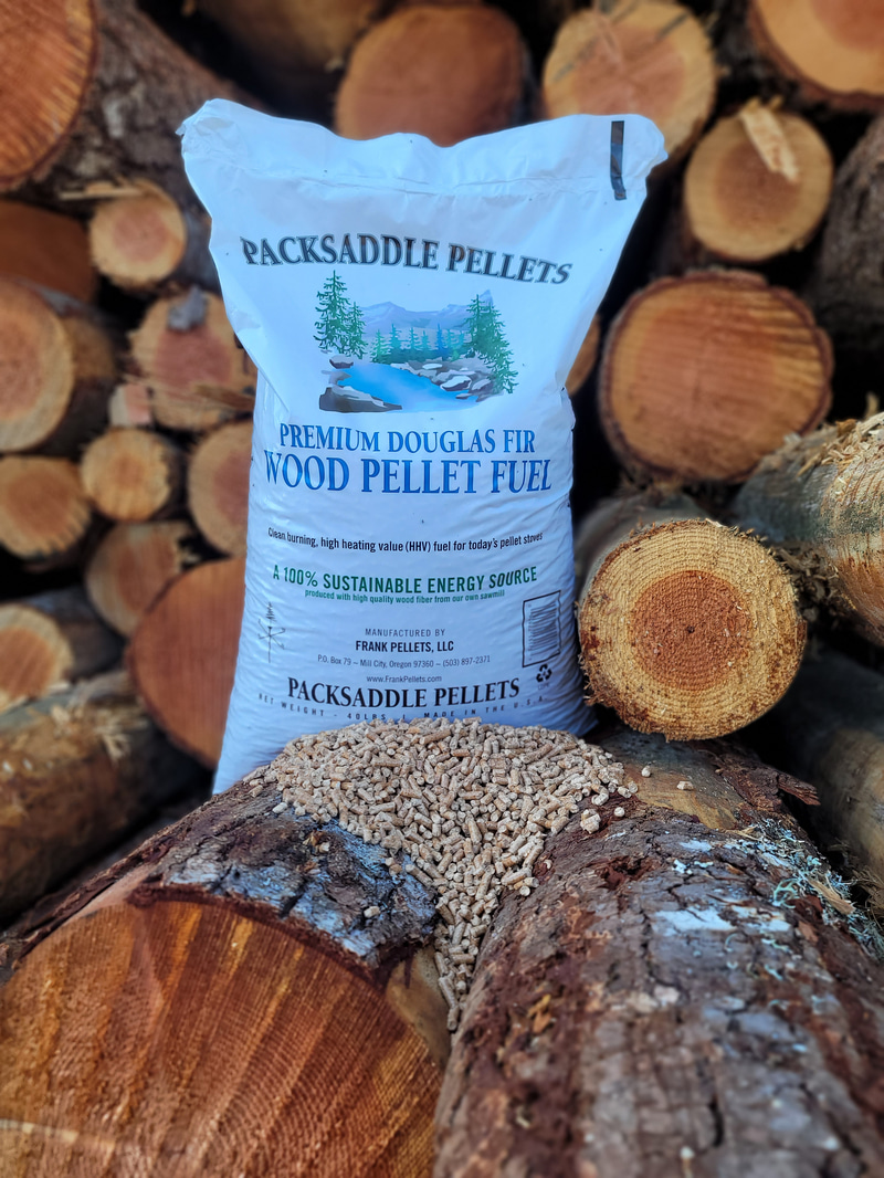 Bag of Packsaddle Douglas Fir wood heating pellets in front of stacked logs