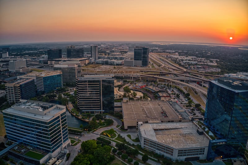 Office towers and surrounding neighborhoods in Plano, Collin County, Texas, at sunset.