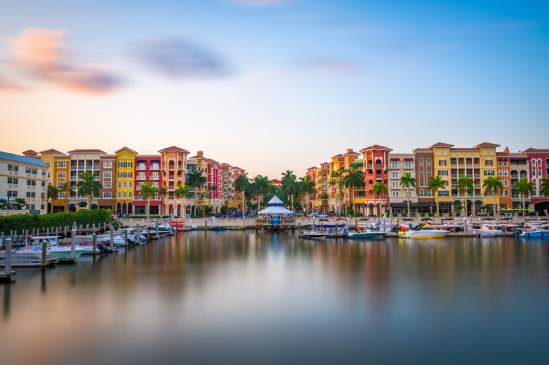 Waterfront buildings and boats in downtown Naples, Florida, at dusk.