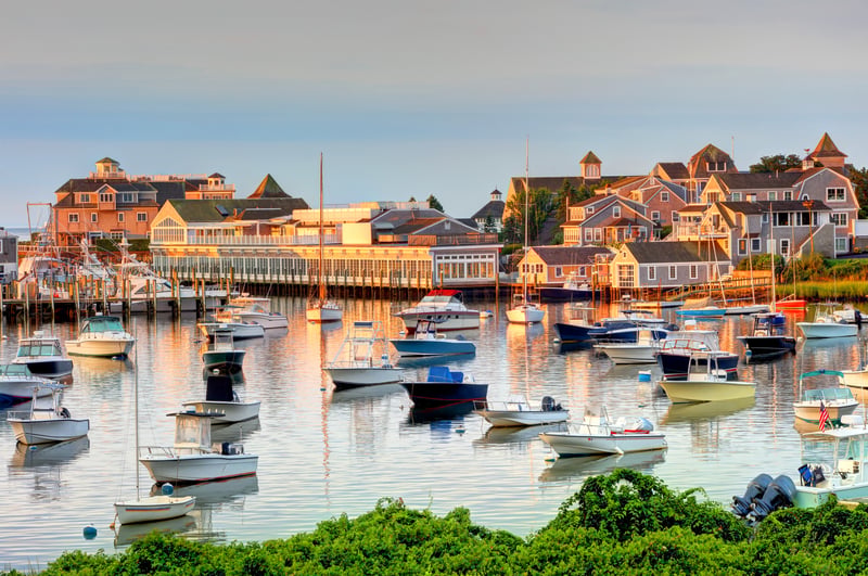 Boats and shingled waterfront buildings at Wychmere Harbor in Harwich on Cape Cod, Massachusetts.