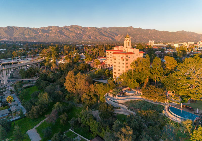 Pasadena, California, at sunset, with a bridge, towered hotel and mountains beyond.
