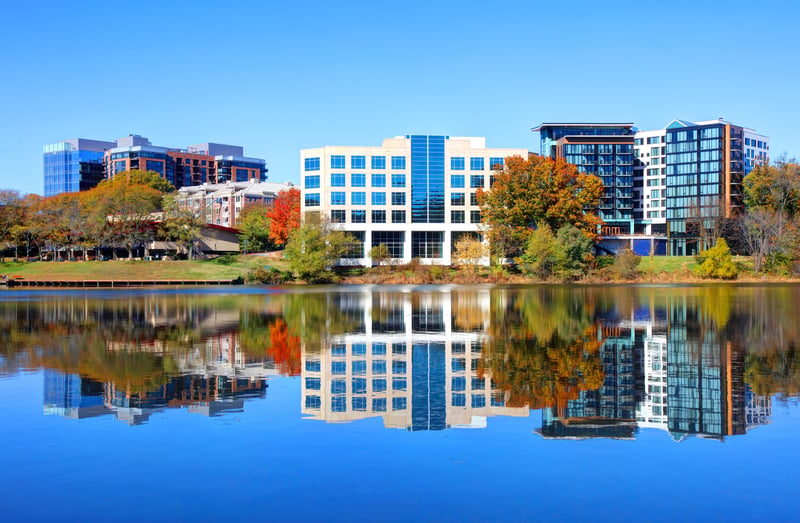 Lakeside buildings in Columbia, Howard County, Maryland, framed by autumn trees.