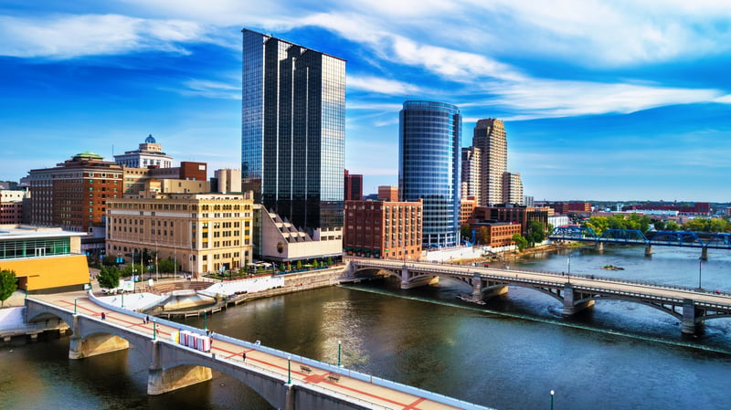Downtown Grand Rapids, Michigan, and bridges across the Grand River beneath a dramatic sky.