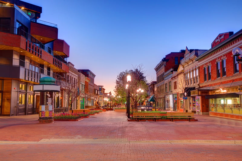 Pedestrian shops, brick storefronts and trees along Pearl Street in Boulder, Colorado.