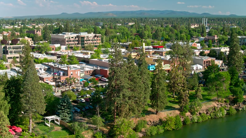 Aerial view of Bend, Oregon, with the River West neighborhood, river and surrounding trees.