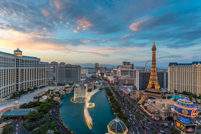 The Las Vegas Strip at sunset, with the Eiffel Tower replica and Bellagio fountains.