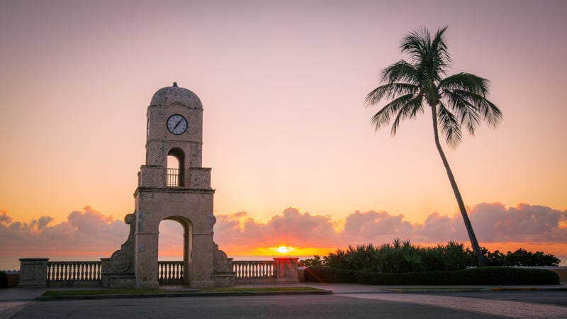 Worth Avenue Clock Tower beside the ocean in Palm Beach, Florida, at sunrise.