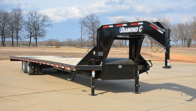 A Diamond C Gooseneck Trailer sits in a parking lot.