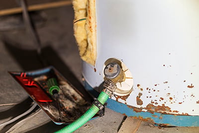 An old water heater is drained.