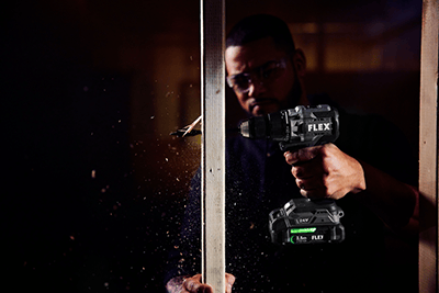 A worker drills a hole in a stud with the FLEX 1/2-inch 2-Speed Drill Driver with Turbo Mode.