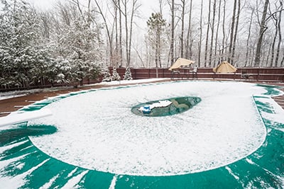 A cover over an inground swimming pool during winter.