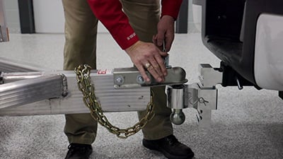 The coupler latch on a trailer is secured with a safety pin.