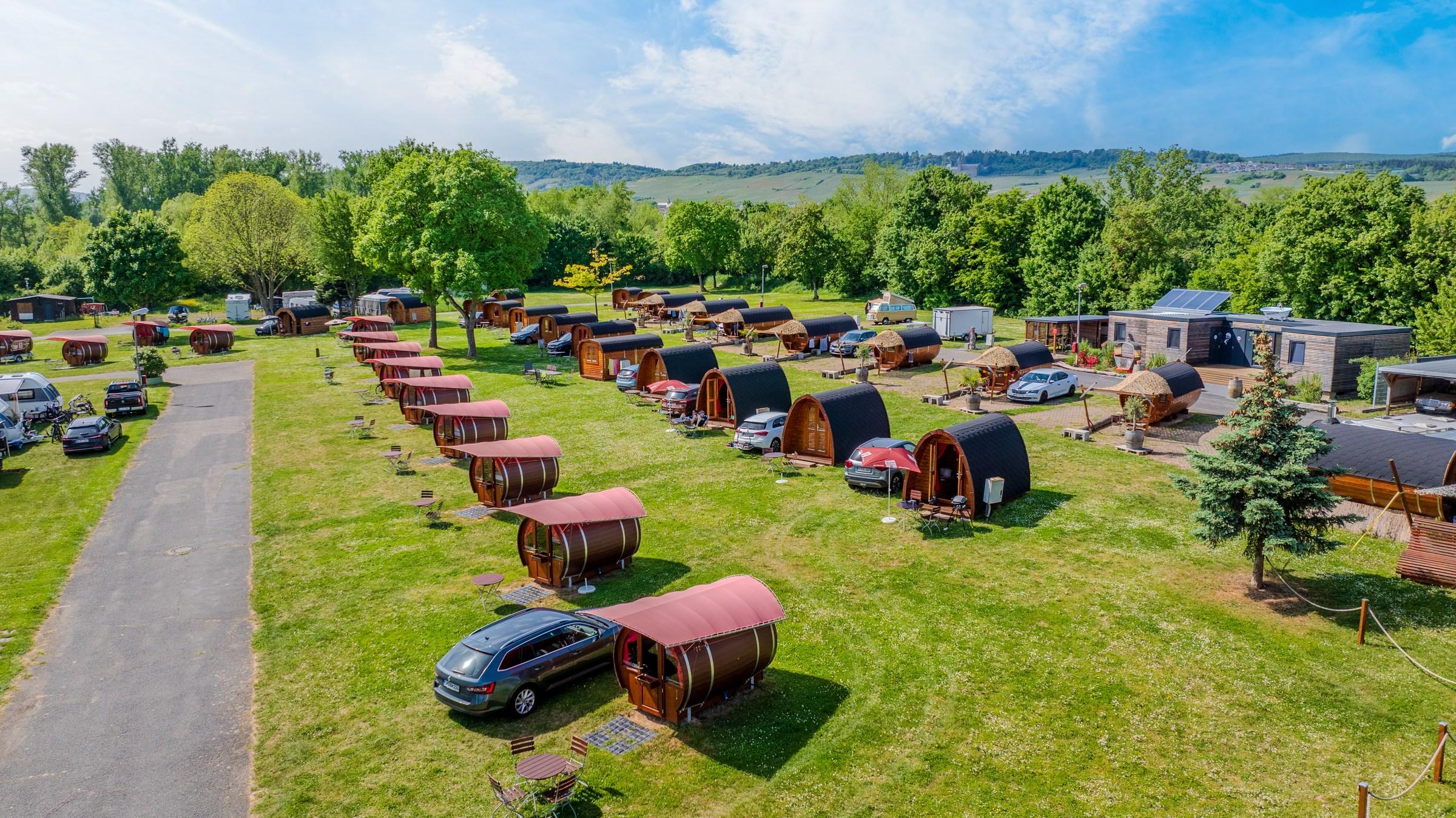 Flygbild över Rheingau 524 Lodges på Rheingaucamping Geisenheim – rader av tunnstugor och campingpods på en äng