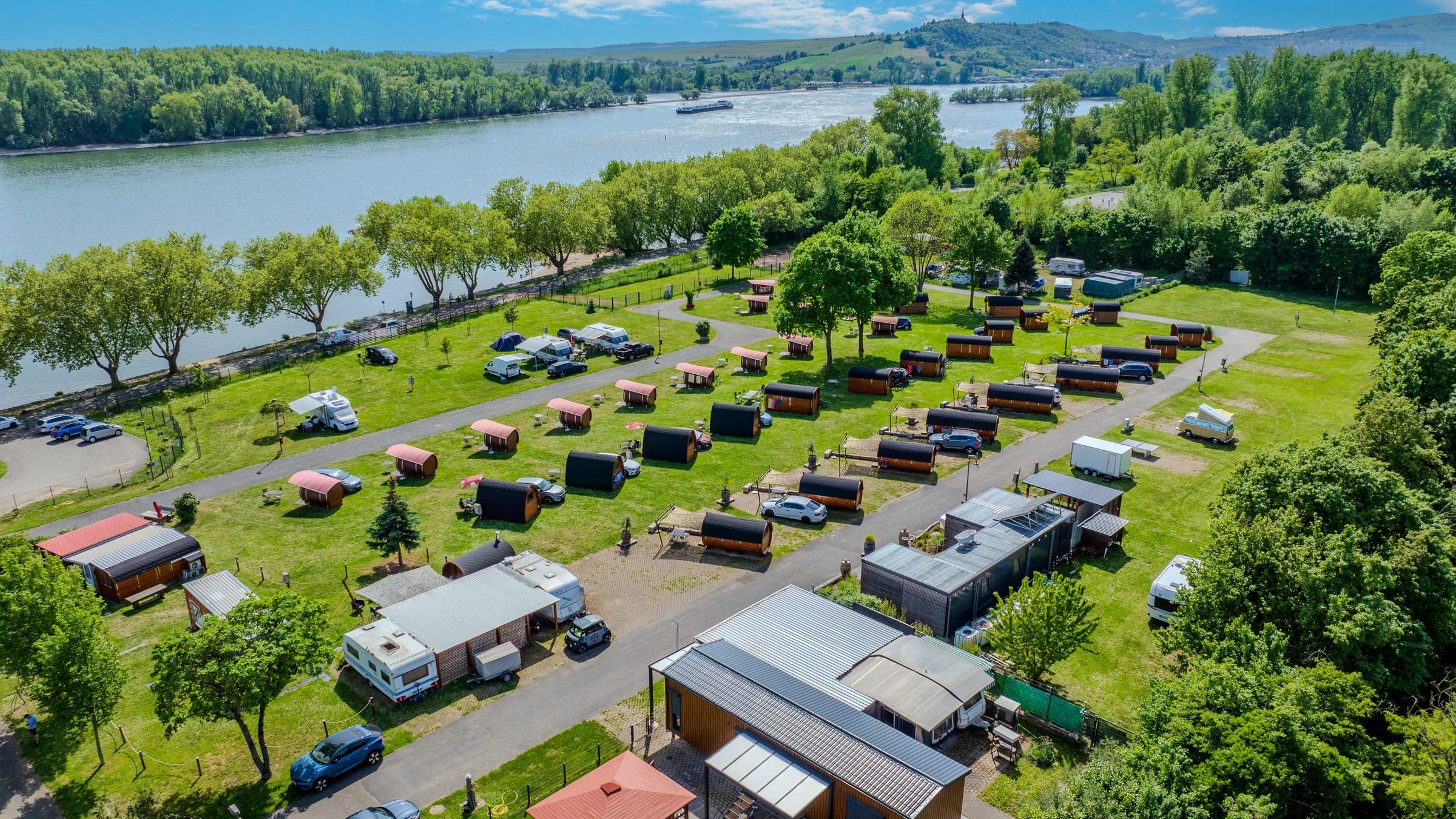 Flygbild över Rheingaucamping Geisenheim direkt vid Rhen – platser, ängar och floden i bakgrunden